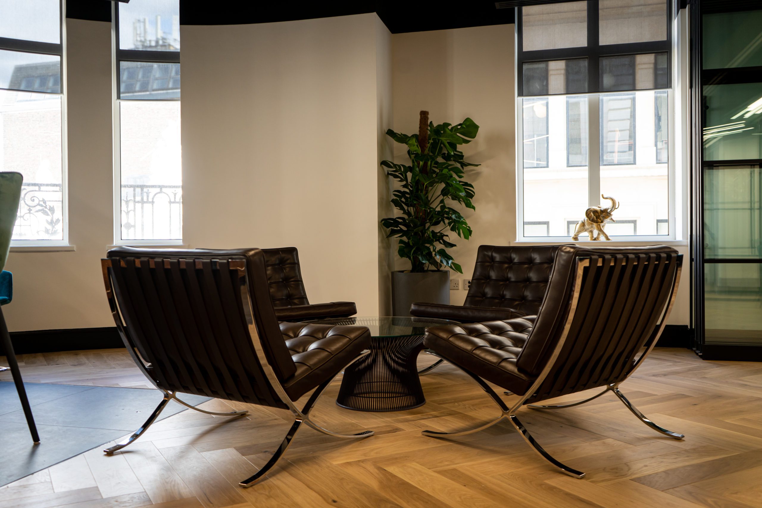 Pair of black leather Barcelona chairs in a bright modern European office